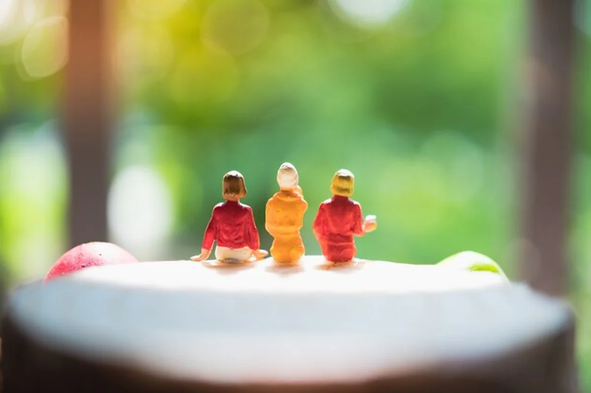 Grupa miniaturowych ludzi siedzących na pieczarkowym szalunku