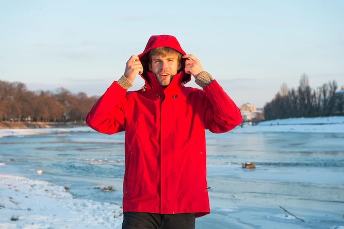 Mężczyzna w ciepłej kurtce na śnieżnym tle
