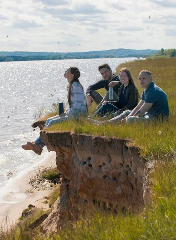 Grupa młodych przyjaciół na wzgórzu wypoczywających na świeżym powietrzu