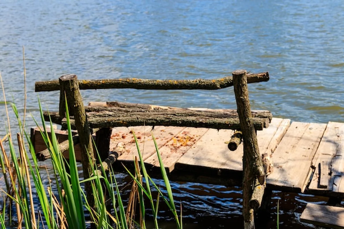 Małe drewniane molo z ławką nad jeziorem