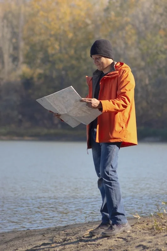 Podróżnik przy jeziorze z mapą jesienią