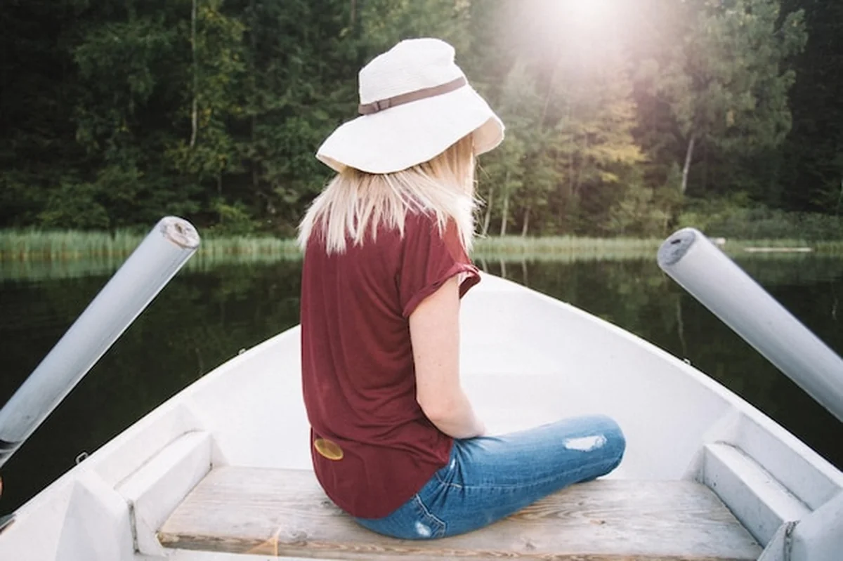 Kobieta siedząca w łodzi na jeziorze