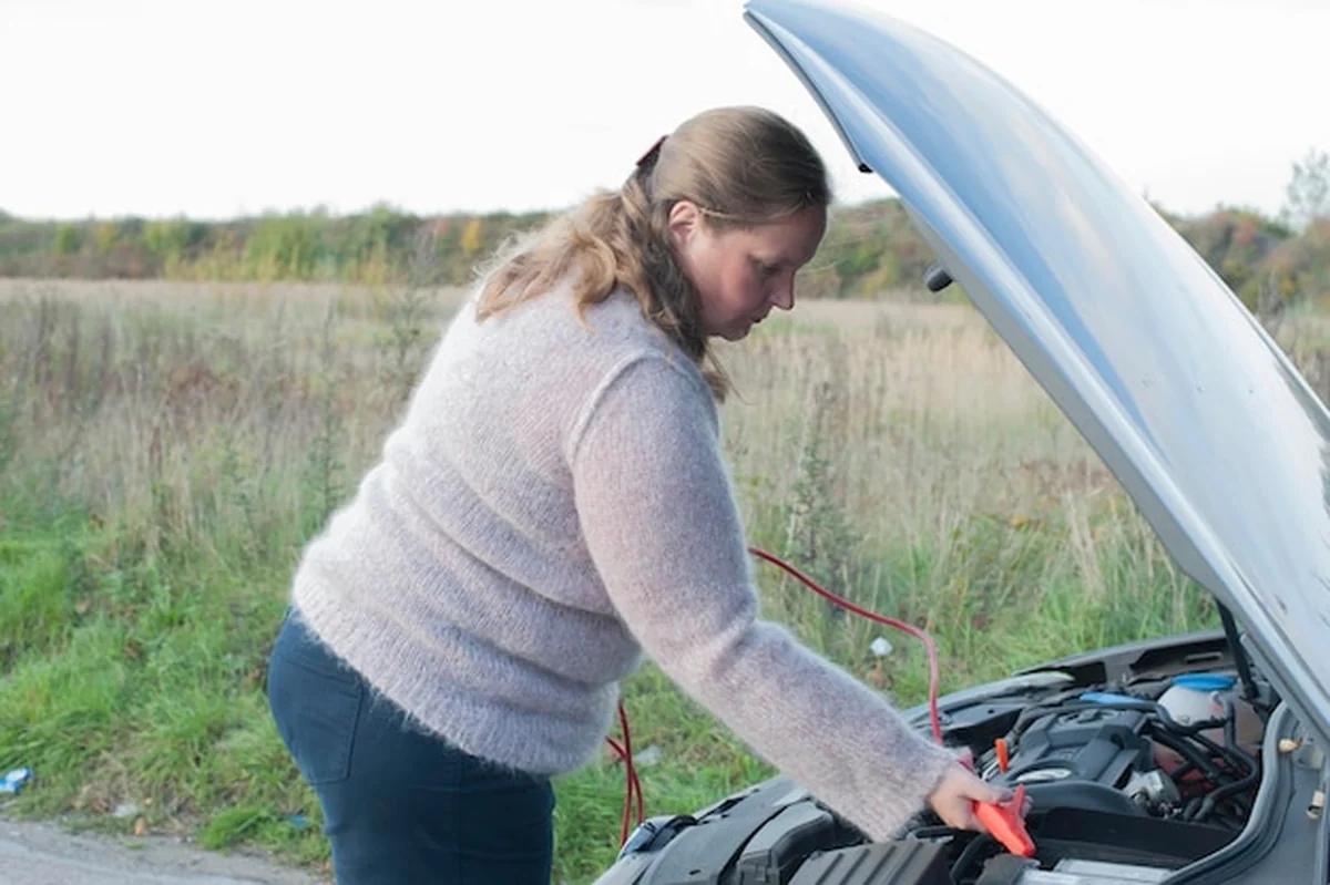 Kobieta naprawia silnik samochodu
